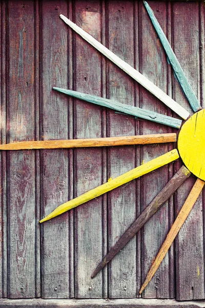 素朴な木製の壁にカラフルな太陽の飾り — ストック写真