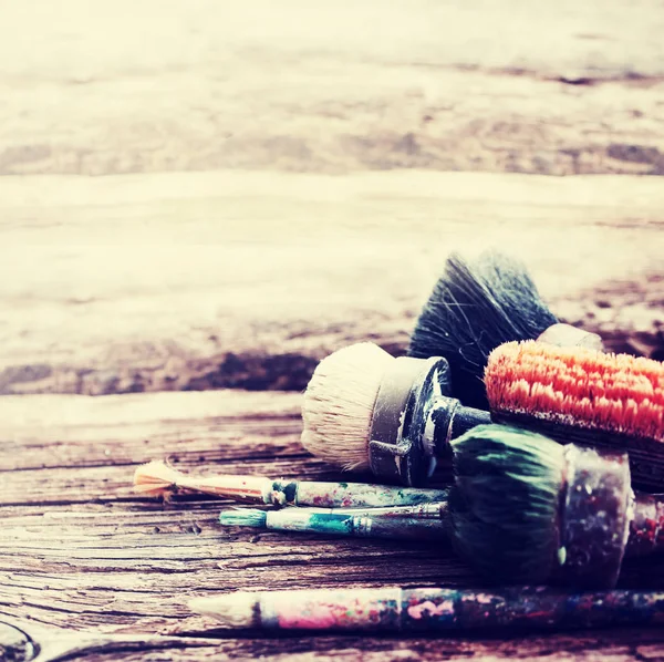 Colorful paintbrushes on wooden background