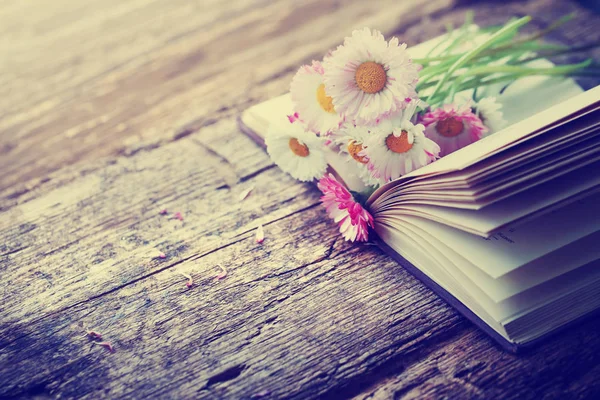 開かれた本の木製のテーブルの上の素朴な花の花束 — ストック写真