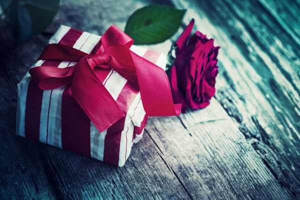 木製の背景にギフト ボックスと柔らかな赤いバラ — ストック写真