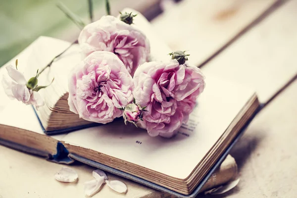 closeup view of natural flowers bouquet over books on wooden surface