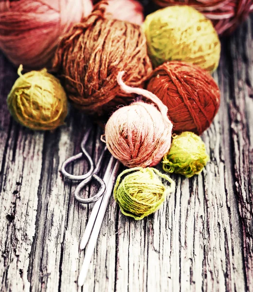 カラフルなスレッドと木製の背景に編み針 — ストック写真