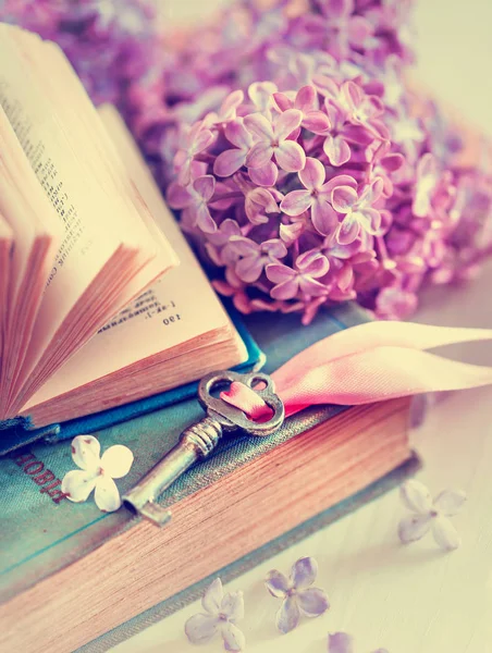 open book with key and lilac flowers