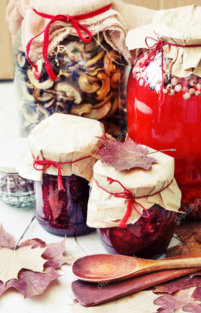 seasonal berry jam, compote and canned mushrooms on wooden table