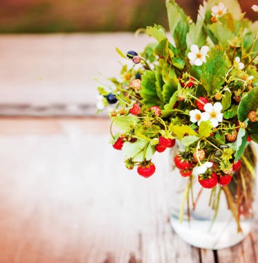 Yaban çilekleri ve yaban mersini yaprak ve Çiçek vazosu ile taze demet