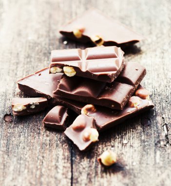 Ahşap arka plan üzerinde fındık ile kırık çikolata
