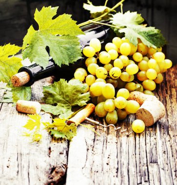 şişe beyaz şarap, üzüm ve mantarlar ahşap tablo