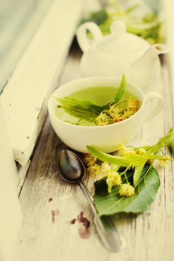 taze çay Kupası ahşap arka plan üzerinde bitkilerle closeup görünümü