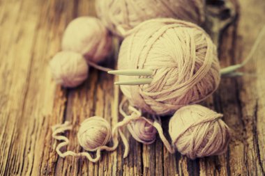 Renkli konu ve örgü iğneleri ahşap arka plan üzerinde