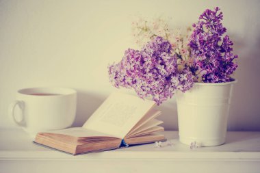 Mor Lila ile açık kitap ve çay ile beyaz fincan