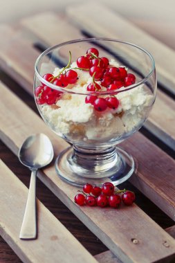 kırmızı meyveler ve ahşap masa kaşık ile cam kapta beyaz dondurma