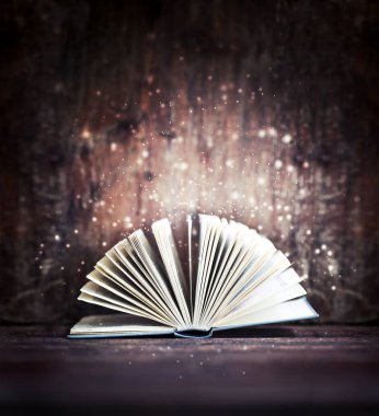 Ahşap masa üzerinde sihirli parlak kitap