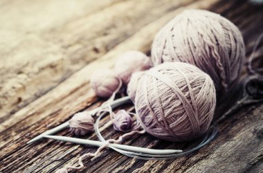 Renkli konu ve örgü iğneleri ahşap arka plan üzerinde