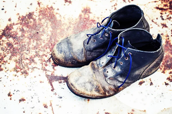 Old dirty vintage boots on rusty metal  surface