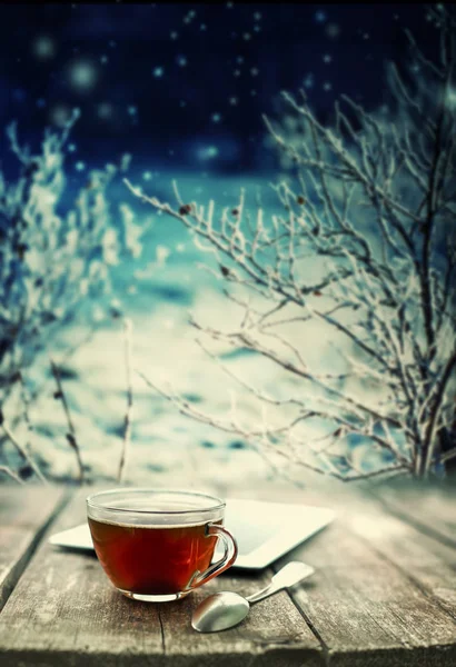 Cup of tea with tablet on wooden table