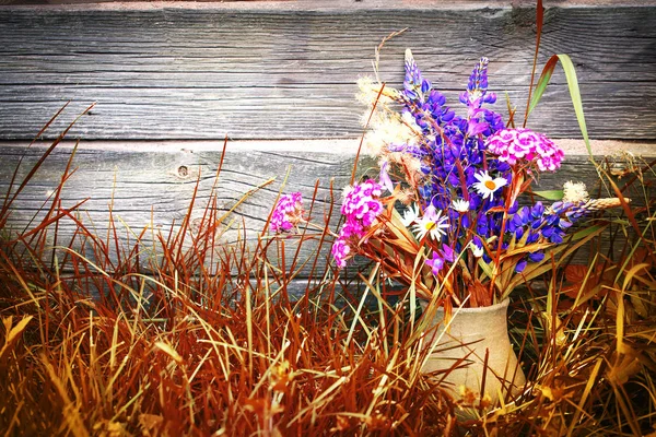 Strauß Bunter Frischer Wildblumen Vase Auf Trockenem Gras Gegen Holzwand — Stockfoto