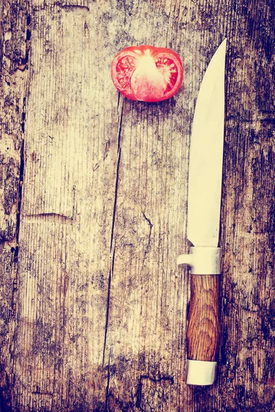 Knife and tomato on wooden table — Stock Photo, Image