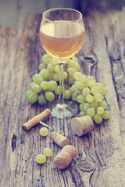 ブドウ 栓抜きコルク木のテーブルと白ワインのグラス — ストック写真