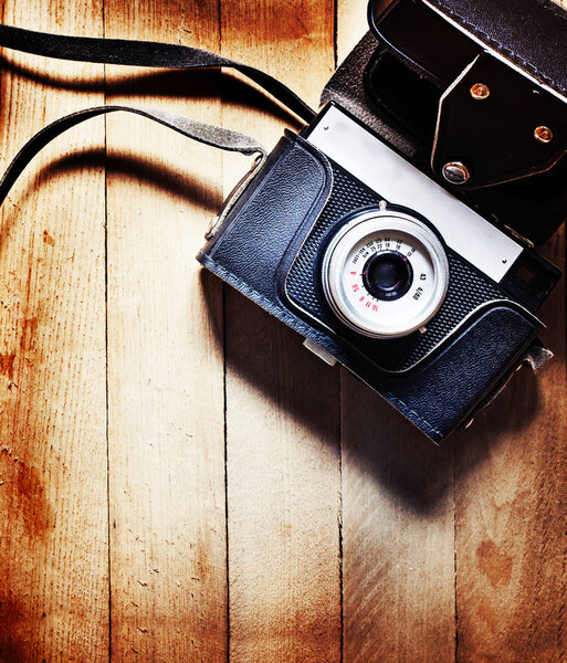 Вид крупным планом винтажной фотокамеры, деревянный фон
