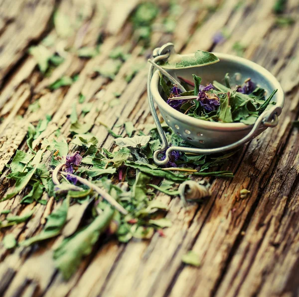 closeup view of dry tea herbs over wooden background