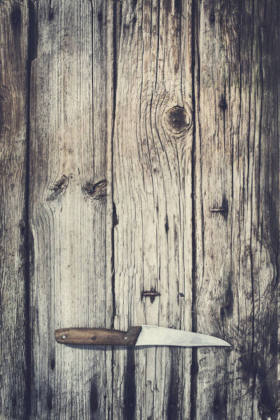 Верхний вид ножа на деревянном фоне
