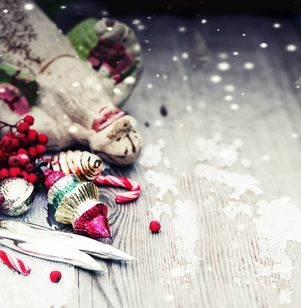 Weihnachtsdekoration Mit Beeren Und Fallendem Schnee Auf Verwittertem Holztisch — Stockfoto