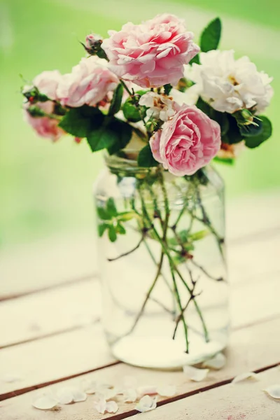 粉红色和白色牡丹玫瑰在罐子上花园木桌 — 图库照片