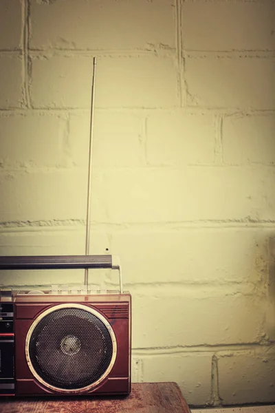 Retro radio player with buttons and antenna on white wall background