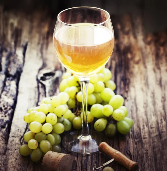 木製テーブルの上の緑のブドウの白ワインのガラス — ストック写真