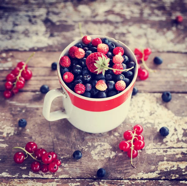 Myrtilles Fraîches Dans Une Tasse Avec Fraise Sur Une Surface Photo De Stock