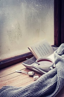 fincan sıcak çay ve kitap ahşap yüzey üzerinde