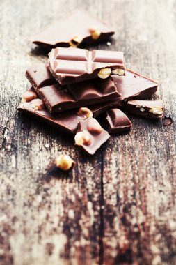 Ahşap arka plan üzerinde fındık ile kırık çikolata