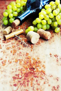 Bir şişe şarap, üzüm ve ahşap masa tarihinde mantarlar