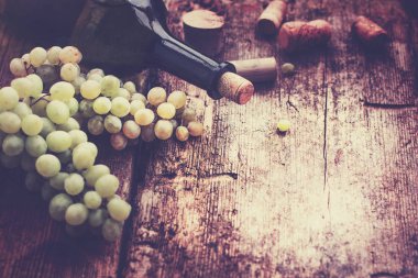 şişe beyaz şarap, üzüm ve mantarlar ahşap tablo