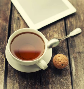 Siyah çay ile tablet ahşap masa üzerinde