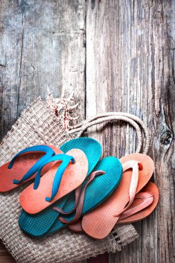 Flip flop hasır tote ahşap yüzey üzerinde renklendirilmiş