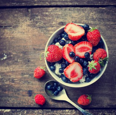 kase ahşap yüzeyde bir yaban mersini ve taze yaban çilekleri