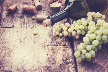 şişe beyaz şarap, üzüm ve mantarlar ahşap tablo