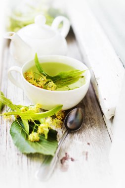 taze çay Kupası ahşap arka plan üzerinde bitkilerle closeup görünümü