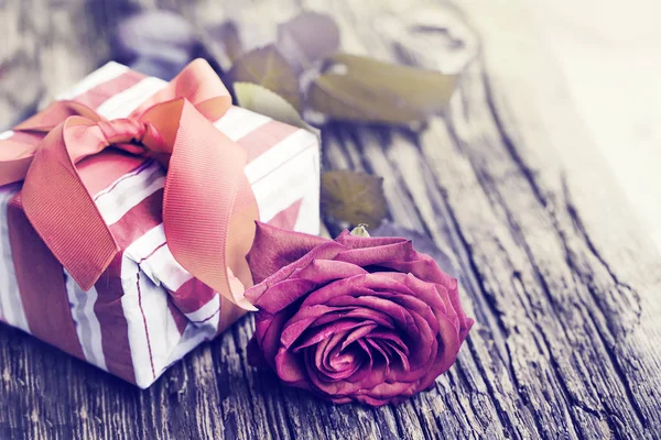 美丽的红玫瑰与礼品盒在木背景 — 图库照片