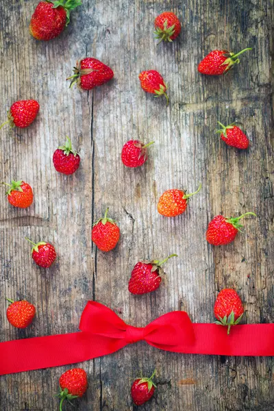 Verse Rijpe Verspreide Aardbeien Houten Oppervlak Met Strik Rood Lint — Stockfoto