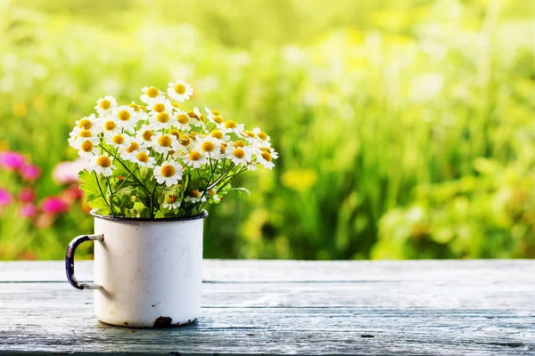 素朴な木製のテーブルを屋外にマグカップで新鮮な鎮静の花束 — ストック写真