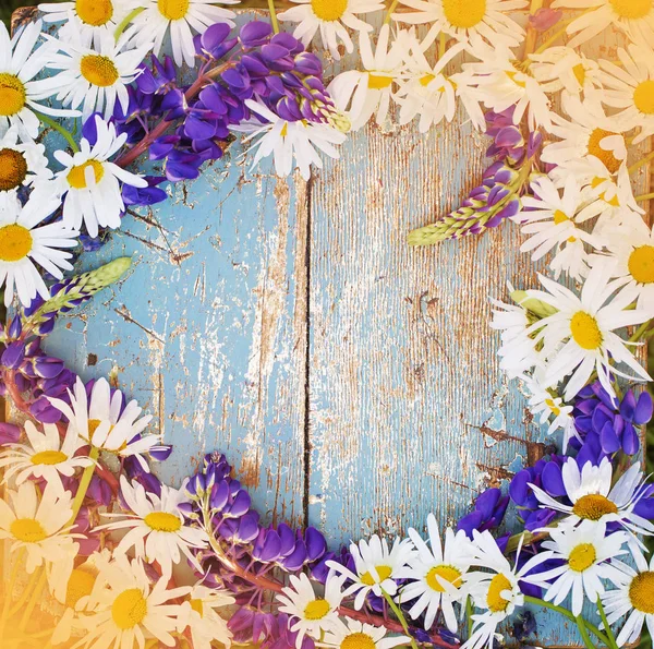 Gänseblümchen Und Lila Blüten Auf Hölzerner Oberfläche — Stockfoto