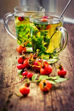 ahşap masa portre görünümünde otlar ile taze çay bardak