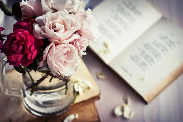 木製テーブルの上の本のガラス瓶の中のバラの花束 — ストック写真