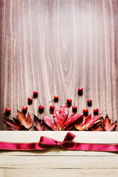 木桌上带丝带的浆果和叶子的顶部视图 — 图库照片