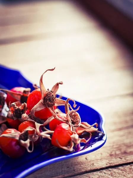 Close Red Rose Hip Berries Dried Leaves Blue Glass Plate — Stock Photo, Image