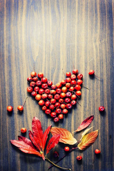 Sfondo Autunnale Con Cuore Fatto Bacche Fogliame Superficie Legno — Foto Stock