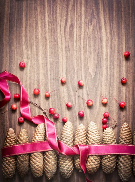 Festive Winter Background Ribbon Berries Cones Wooden Surface — Stock Photo, Image