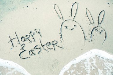 El ile tebrik happy Easter bunnies ıslak kum deniz arka planda yazılı çizilmiş 
